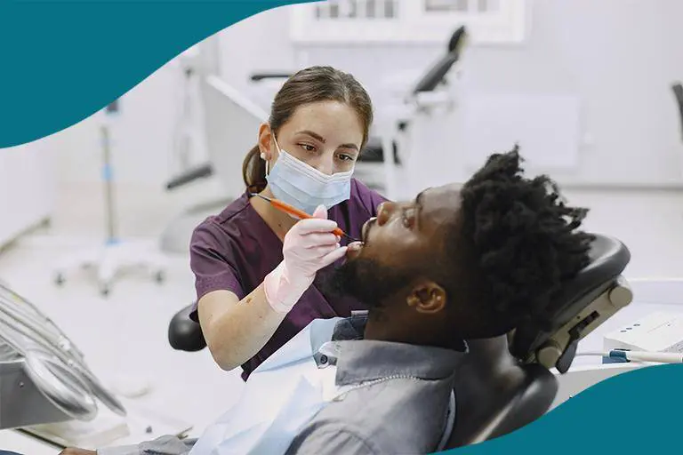 Tandhygienist undersöker patient.