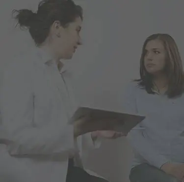 En gynekolog samtalar med en patient.