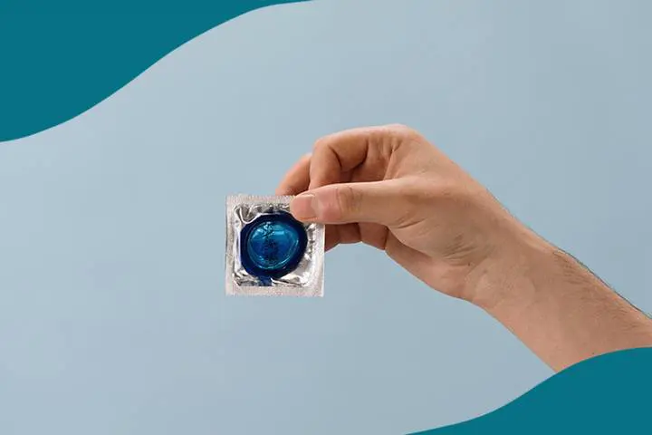 En hand som håller upp ett preventivmedel