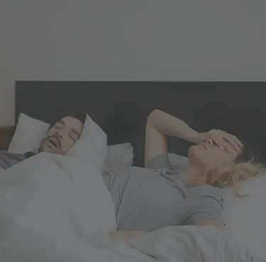Person har svårt att sova på grund av partner som snarkar