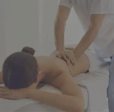 Person som ligger på brits får massage.