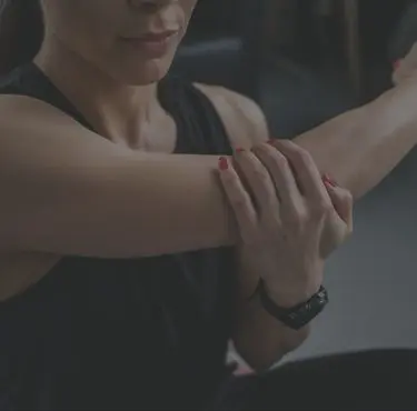 En person som håller sig för sin armbåge.