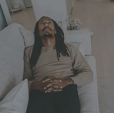 En man ligger på en soffa och en person för anteckningar.