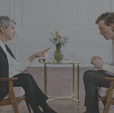 En patient blir tilltalad av en terapeut som sitter mittemot.