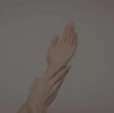 En person håller om sin egen handled.