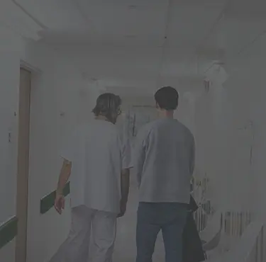 En manlig patient och en urolog går genom en sjukhuskorridor.