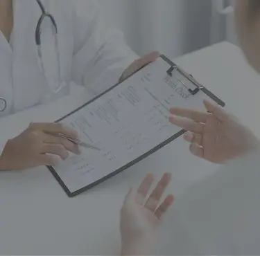 En gynekolog visar ett formulär för en patient.