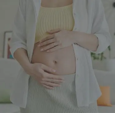 En gravid person håller händerna runt sin mage.