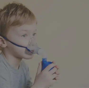Barn med cystisk fibros andas genom syrgasmask.