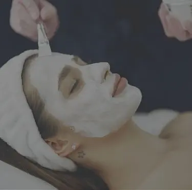 En person får en ansiktsbehandling med peeling.