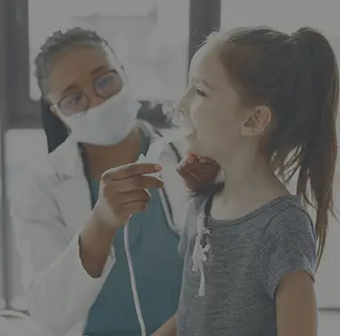 Läkare med munskydd gör en astmautredning på en patient.