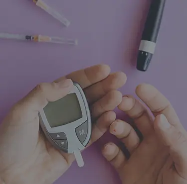 En person får behandling av diabetes genom en en blodsockermätare.