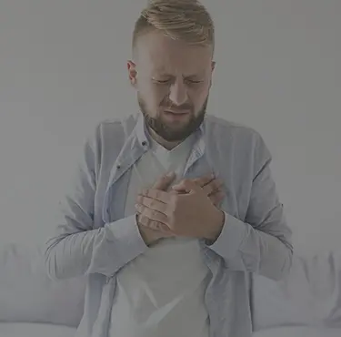 Man med halsbränna håller för bröstet