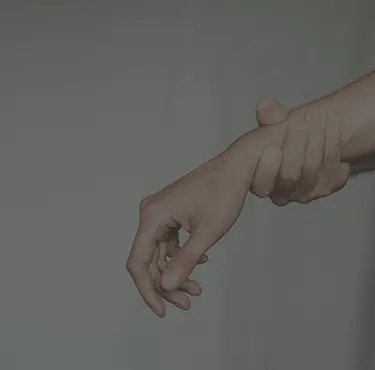 En person som håller om sin handled.
