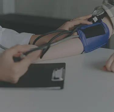 Läkare mäter blodtryck för att se om patient har hjärtflimmer.
