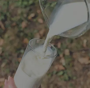 Person med laktosintolerans häller upp ett glas mjölk