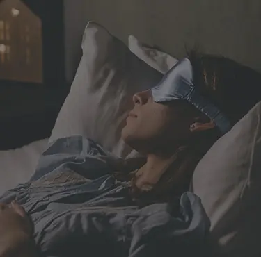 Kvinna som sover med sovmask.