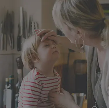 En mamma tittar till sin sons ögoninflammation