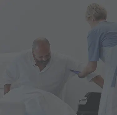 Vårdpersonal hjälper en patient som drabbats av förgiftning upp ur sjukhussängen