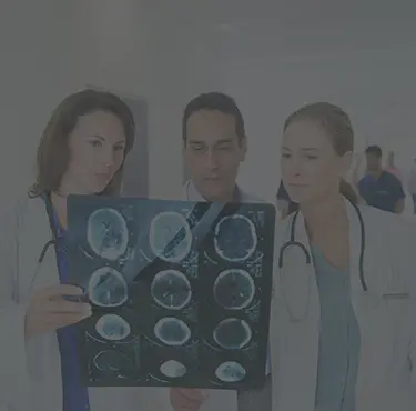 Tre neurologer avläser en röntgenbild av en hjärna