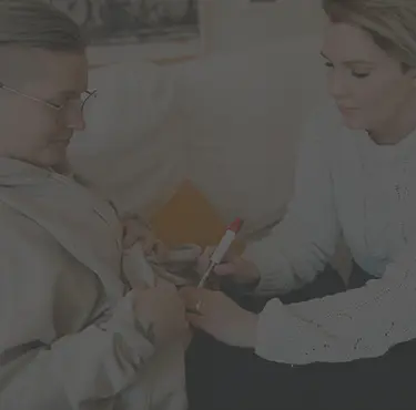 En kvinna får en spruta av en annan kvinna inför IVF behandling.