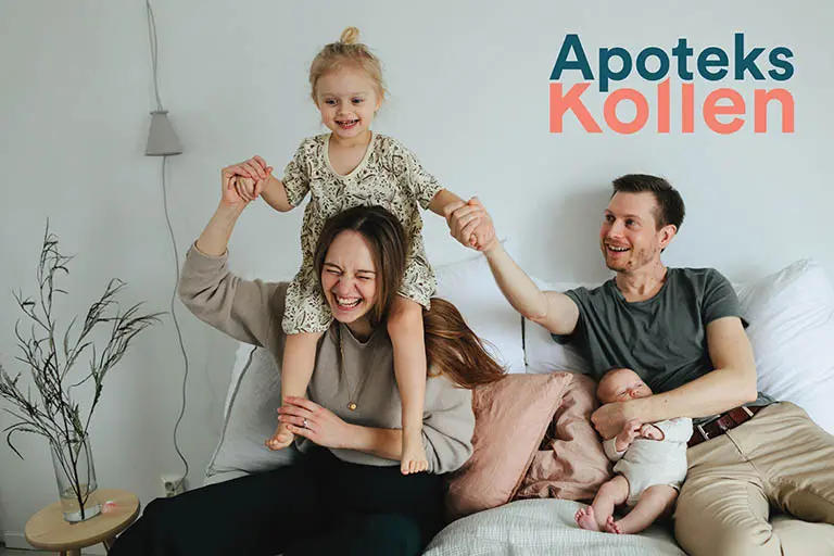 Glad familj sitter tillsammans på en soffa